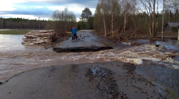 Valokuvassa asfaltoitu tie, joka on katkennut tulvavesien vyöryessä tielle.