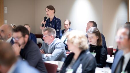 Seminaariyleisöä ja yksi henkilö mikrofonin kanssa