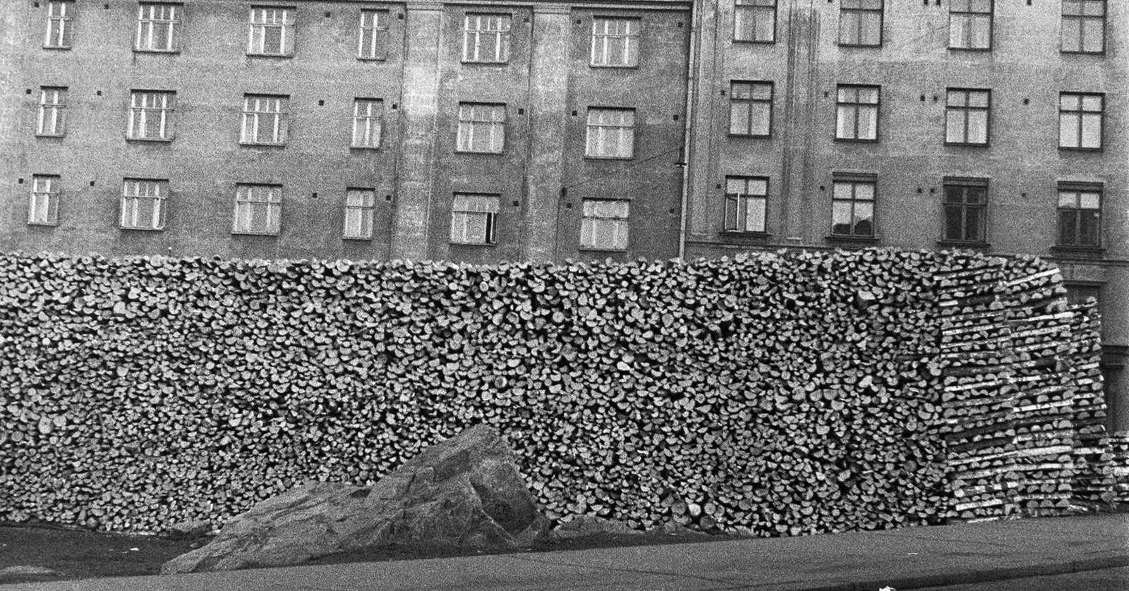 Halkopinot kuuluivat vielä 1960-luvulla normaaliin helsinkiläiseen katukuvaan. Suuri halkopino talon edessä 1950-luvulla, valokuva.