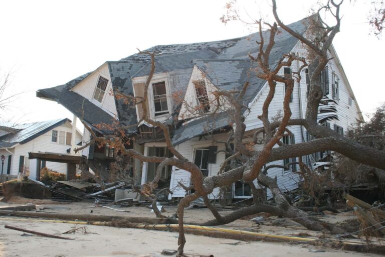 Valokuvassa hirmymyrskyn romahduttama talo ja kaatunut puu.