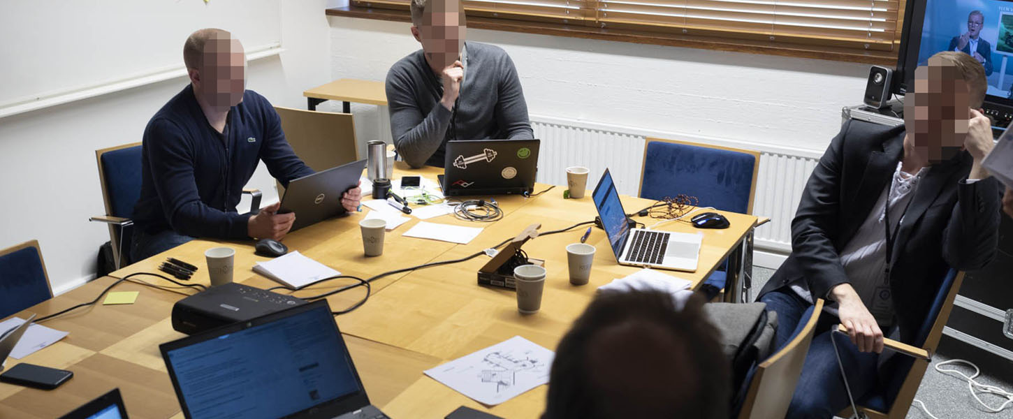 Henkilöitä pöydän ääressä tieto-harjoituksessa, valokuva.